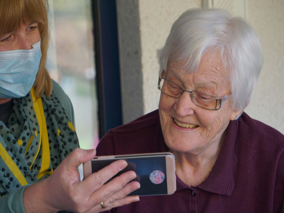 Elderly woman smiling while viewing phone screen