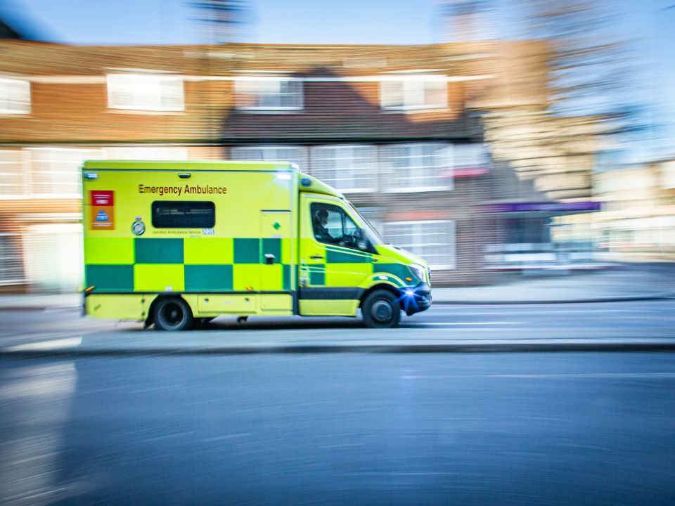 Emergency ambulance speeding down urban street