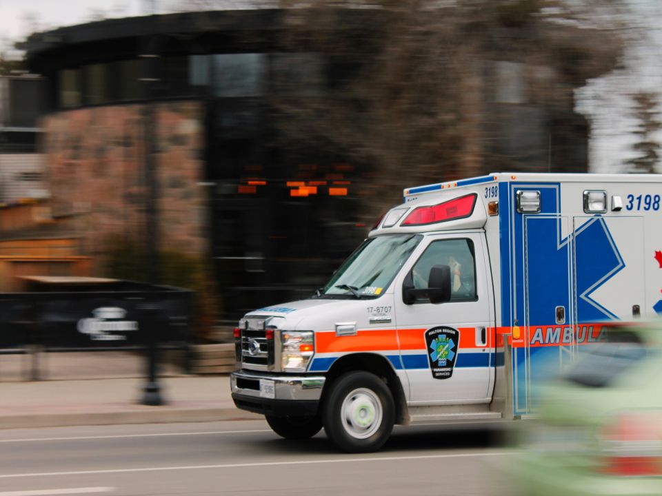 Ambulance rushing down the road, urban setting