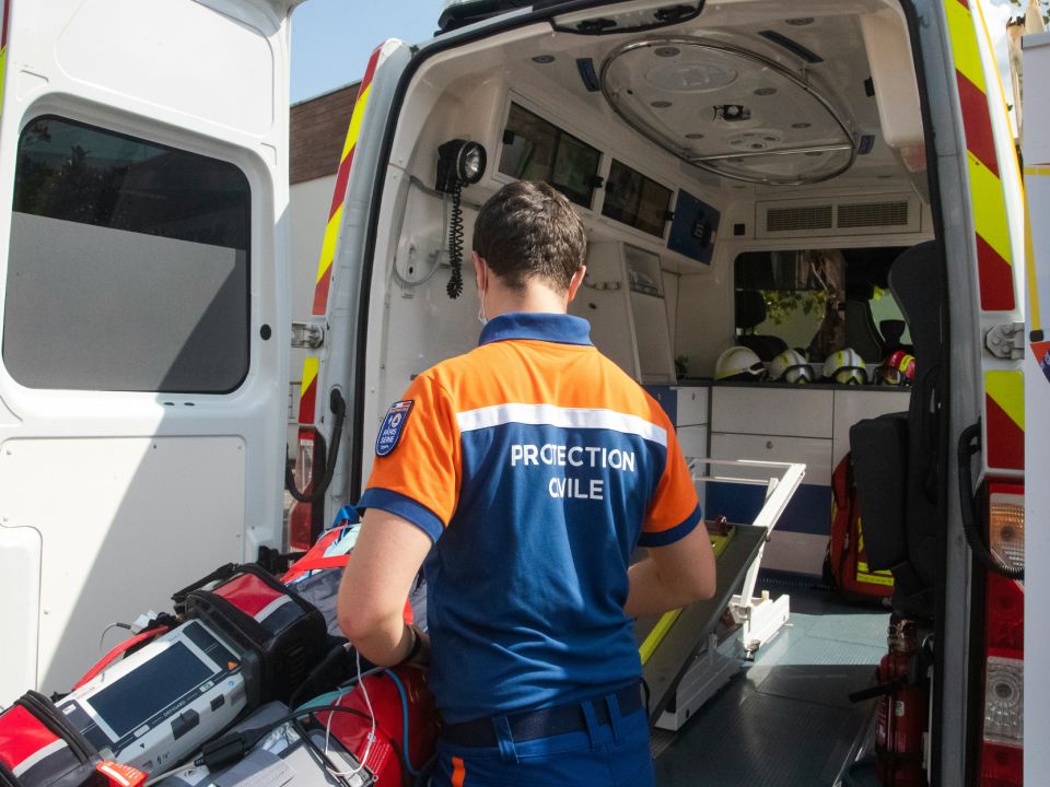 Emergency responder preparing medical equipment in ambulance